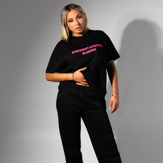 Person wearing a black t-shirt with red text on a gray background