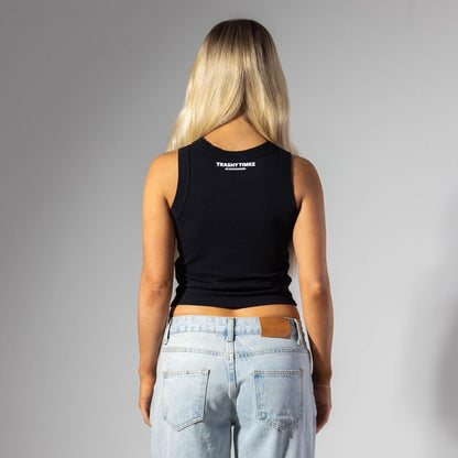 Person wearing a black tank top with a logo on the back, standing against a gray background